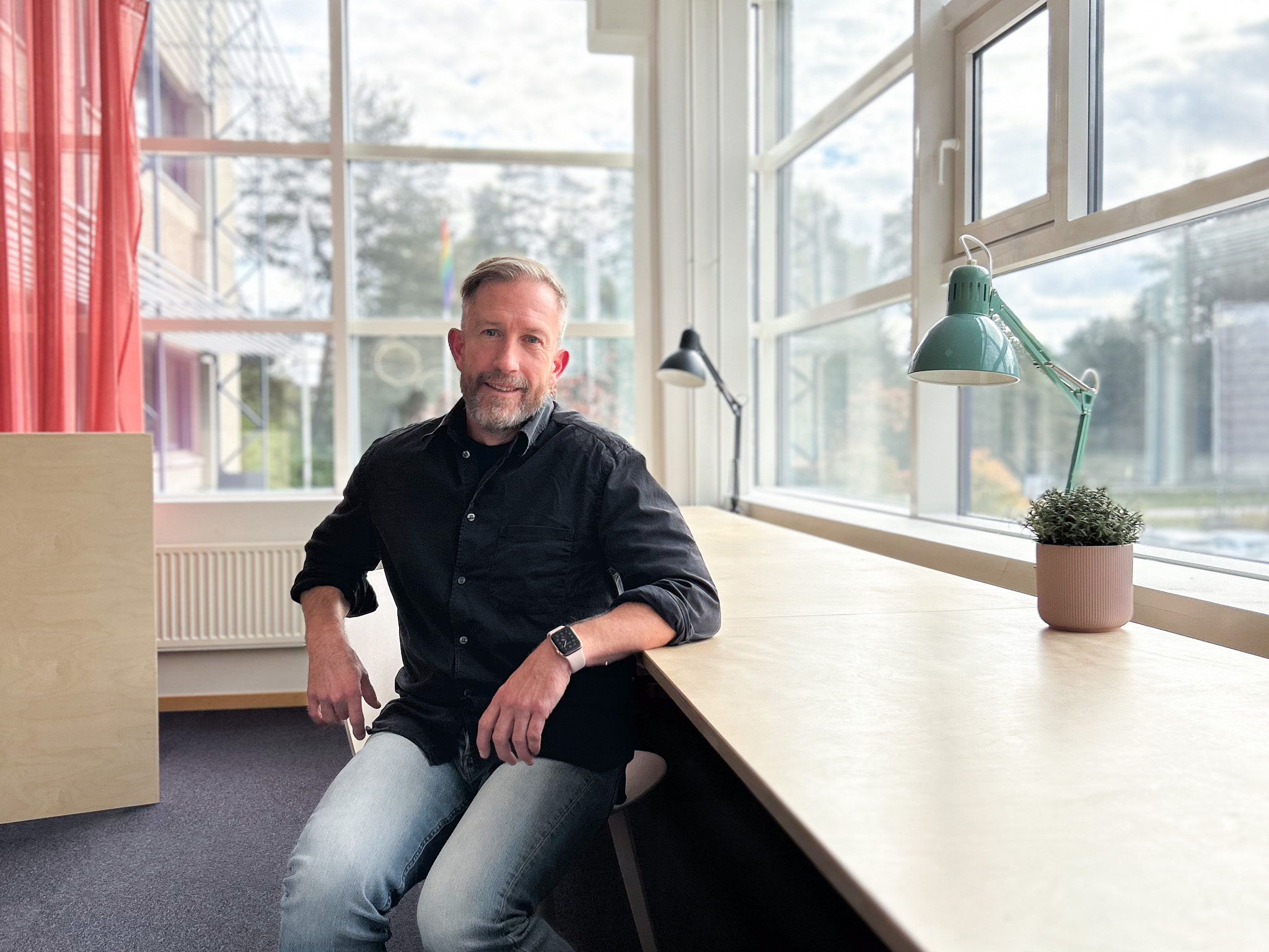 Man i mörk skjorta som sitter ner på en stol.