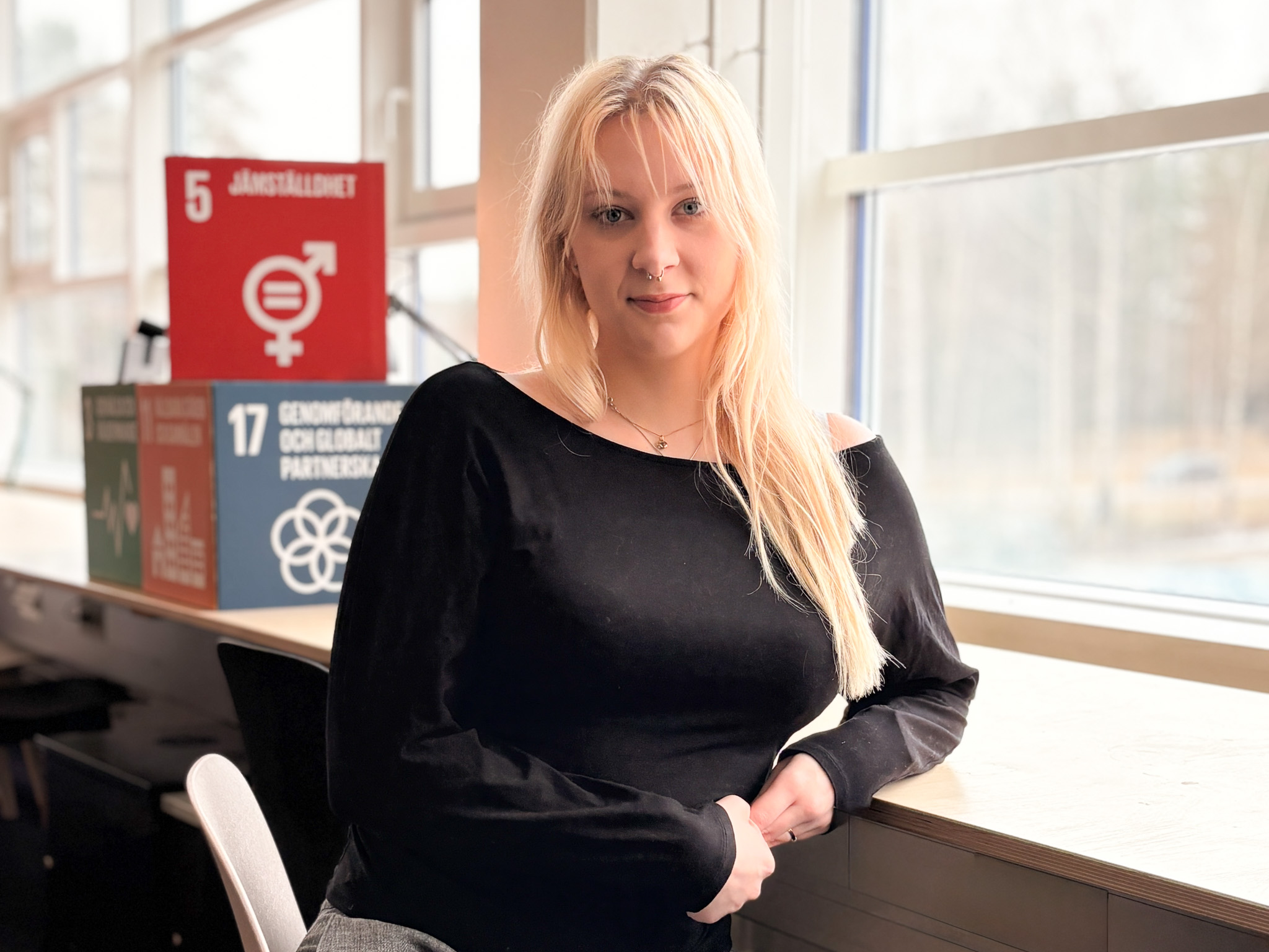 Kvinna som sitter vid fönster.